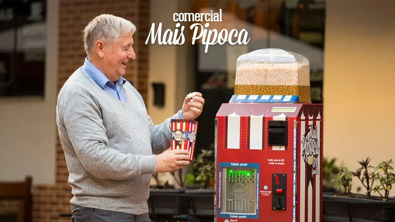 A Mais Pipoca popcorn vending machine demonstrated to a customer.